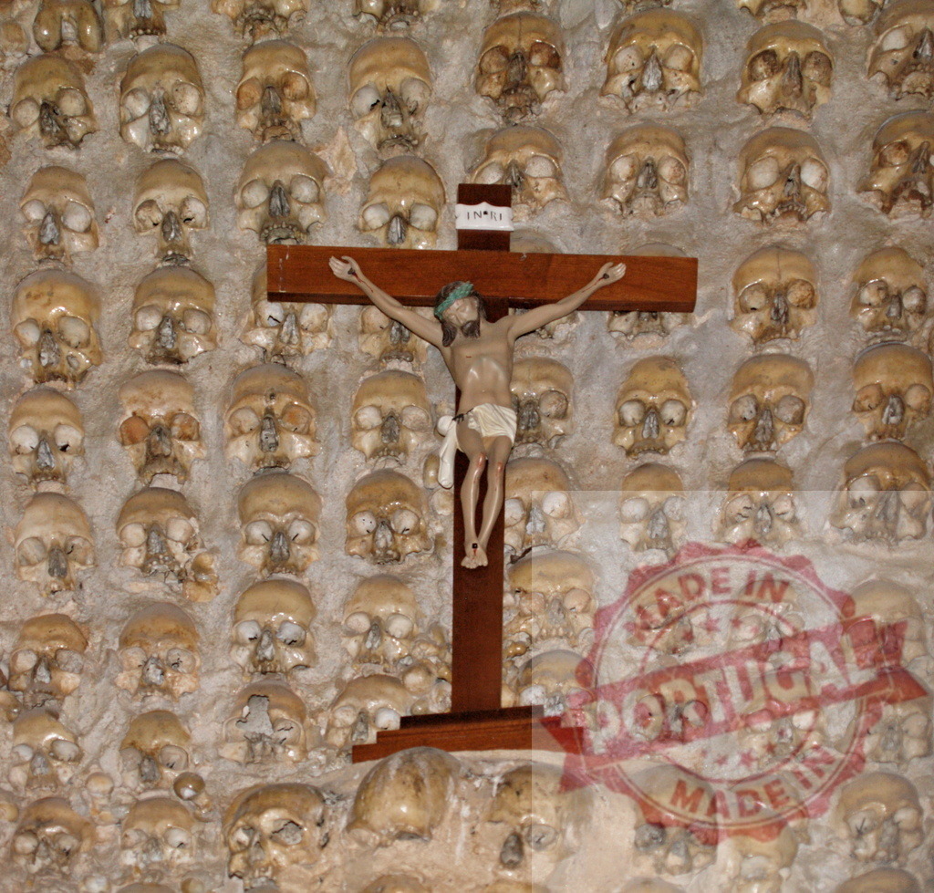 Jesus Christ crucifix surrounded by human skulls in ossuary | Capela dos Ossos showing countless human skulls with crucifix representing memento mori - Realisiert mit Pictrs.com