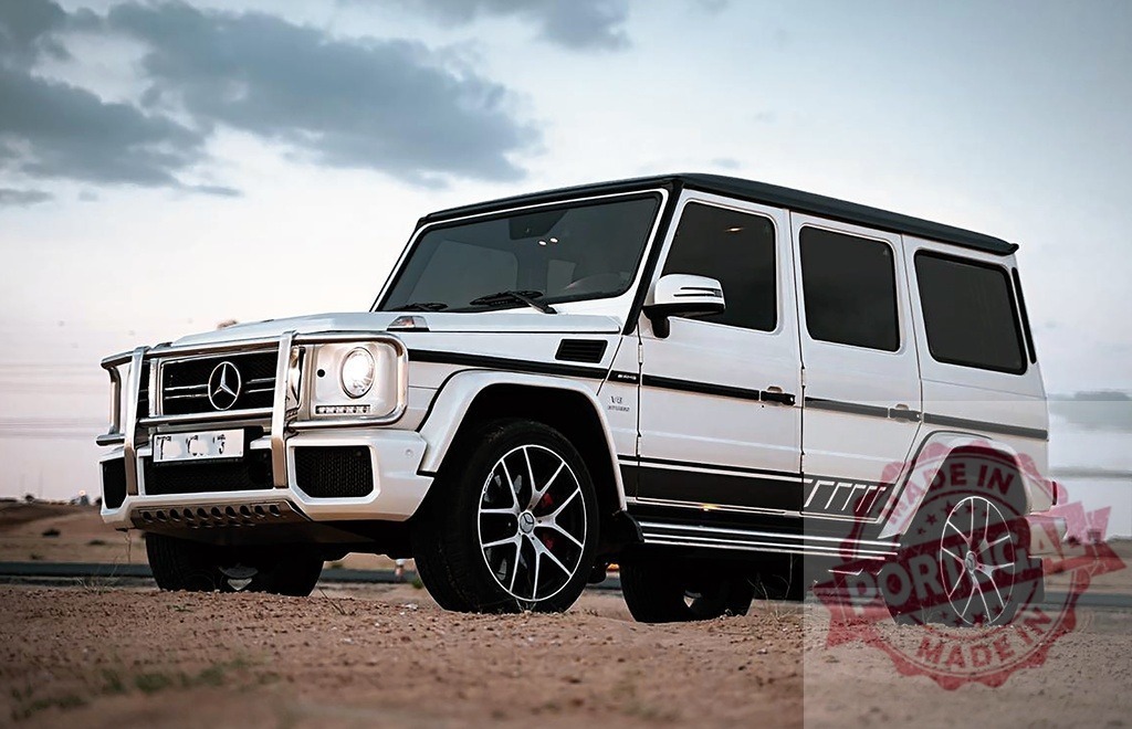 White Mercedes-Benz G-Wagen G63 AMG SUV parked in desert | White luxury off-road Mercedes-Benz G-Wagen G63 AMG parked on dry sand under cloudy sky - Realized with Pictrs.com