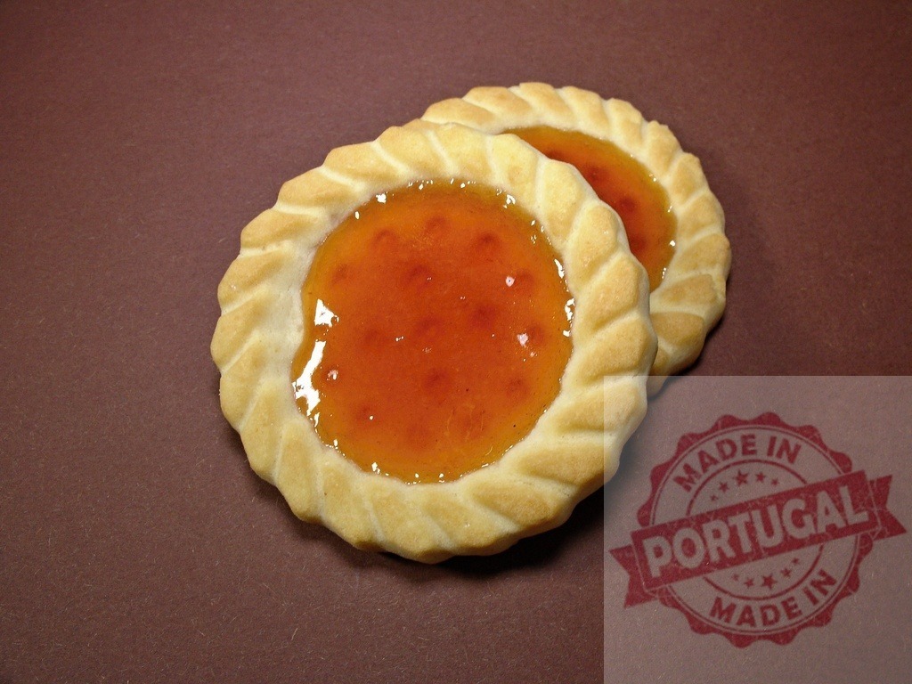Two apricot jam cookies on brown background | Two round sweet pastries with orange jam filling, perfect for dessert - Realisiert mit Pictrs.com