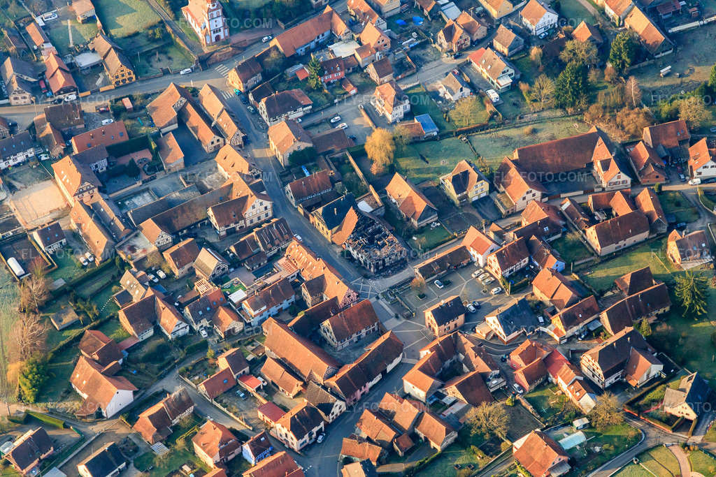 Aerial view: Town hall and burned-down house in the Ru de l'Ouest in Weinbourg in the state Bas-Rhin, France. – Photo: IMG_105297.jpg taken on 03/25/2018 by Werner Riehm/FLY-FOTO.com – Resolution of the original: 5472 x 3648 px