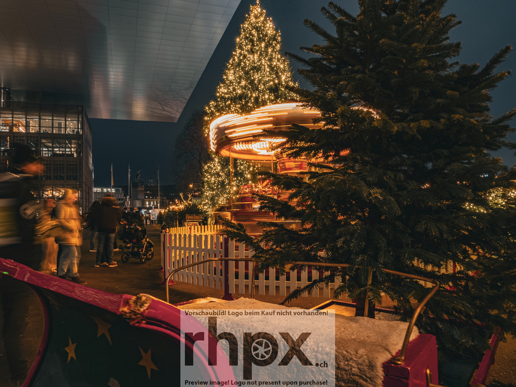 Weihnachtskarussell am KKL | <p><strong>Lichter. Bewegung. Weihnachtszauber.</strong></p><p>Unter dem modernen Dach des KKL verschwimmen die Lichter des Karussells zu warmen Farbspuren. Die festliche Atmosphäre auf dem Europaplatz verbindet dynamische Bewegung mit weihnachtlicher Vorfreude.</p><p>Wähle unter "Produktauswahl" dein Wunschformat: Vom klassischen Wandbild über Puzzle & Tassen bis zum digitalen Download (z.B. als Handy-Hintergrund).</p> - Realisiert mit Pictrs.com