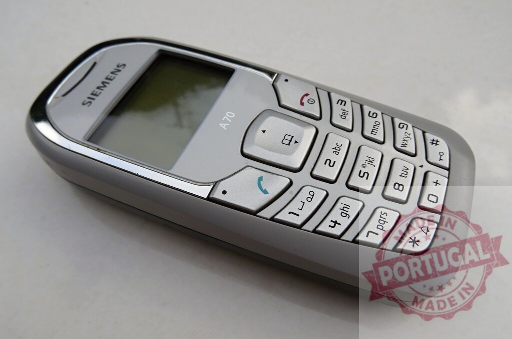 Siemens A70 mobile phone showing keypad and screen | Old Siemens A70 cell phone lying on a white surface - Realized with Pictrs.com