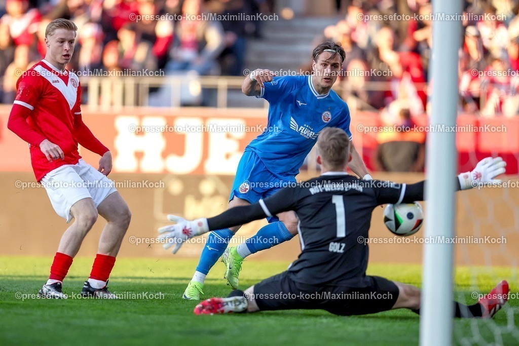 RWE06042501025 | 2025.04.06, Fußball, 3.Liga, Rot-Weiss Essen - FC Hansa Rostock, Stadion Hafenstraße, Saison 2024 2025: Sigurd Haugen (FC Hansa Rostock #18) Schuss auf das Tor von Torwart Jakob Golz (RWE #1) DFB regulations prohibit any use of photographs as image sequences and or quasi-video.