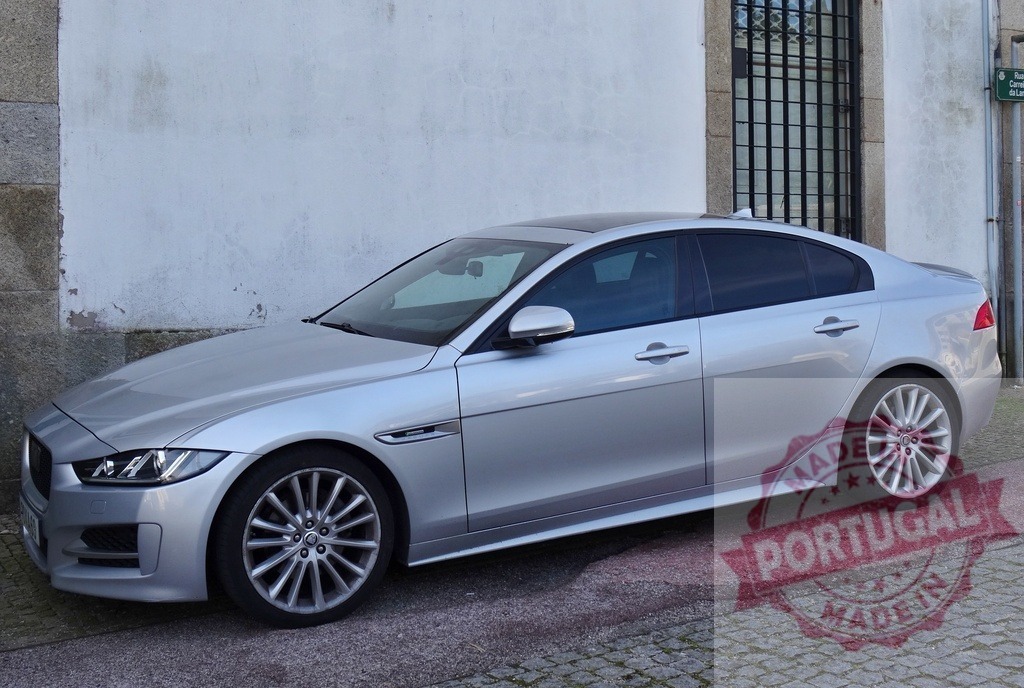 Silver Jaguar XE luxury sedan parked street | Silver Jaguar XE luxury sedan parked by a rough white wall and window - Realisiert mit Pictrs.com