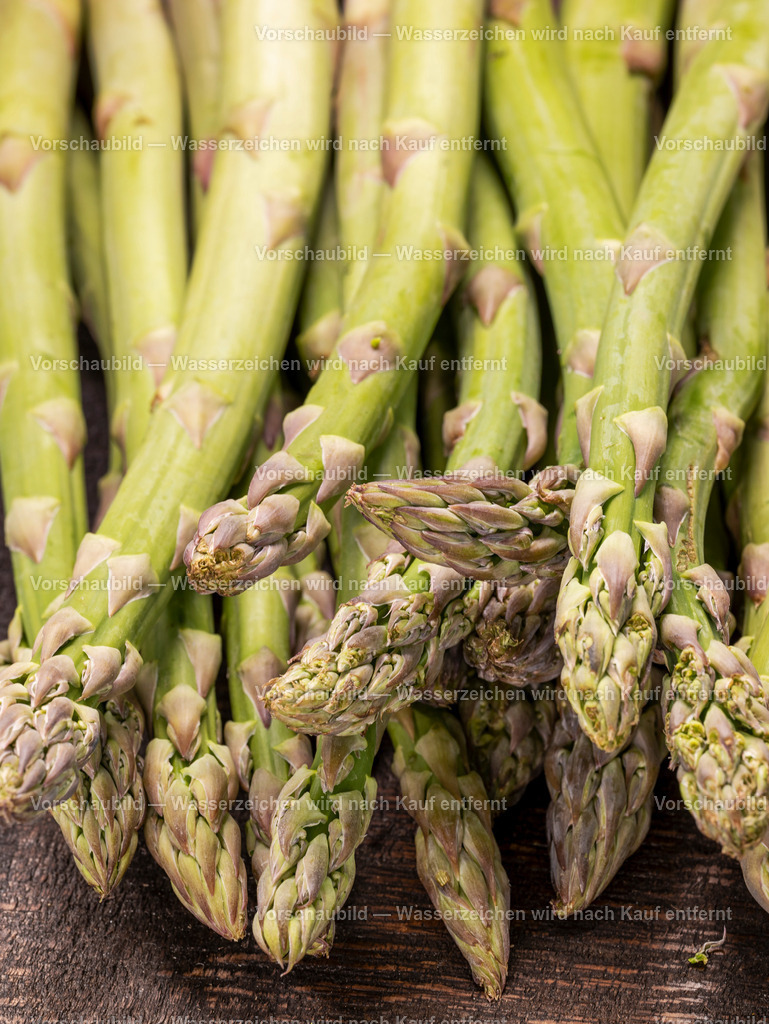 Nahaufnahme von fristen und rohen grünen Spargelstangen auf alten Holzbrett | Nahaufnahme von fristen und rohen grünen Spargelstangen auf alten Holzbrett - Realisiert mit Pictrs.com