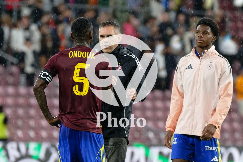 UEFA Conference League Play-offs 2nd leg - Servette FC v FC Shakhtar Donetsk | Jocelyn Gourvennec (Coach Servette FC) comforts Gael Ondoua (5 Servette FC) Jamie Atangana (45 Servette FC) is watching during the UEFA Conference League Play-offs 2nd leg match between Servette FC and FC Shakhtar Donetsk at Stade de Geneve in Geneva, Switzerland