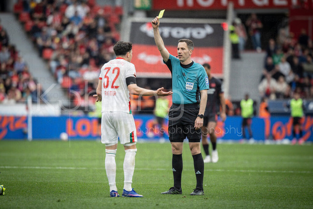German Bundesliga, Bayer 04 Leverkusen vs. FC Augsburg, 18.04.2026 | LEVERKUSEN, GERMANY - APRIL 18, 2026 :  Referee Benjamin Brand (Schwebheim) shows Fabian Rieder (FC Augsburg, 32) the yellow card during the German Bundesliga match on gameday 30 between Bayer 04 Leverkusen vs. FC Augsburg at BayArena on April 18, 2026 in Leverkusen, Germany. DFL REGULATIONS PROHIBIT ANY USE OF PHOTOGRAPHS AS IMAGE SEQUENCES AND/OR QUASI-VIDEO.