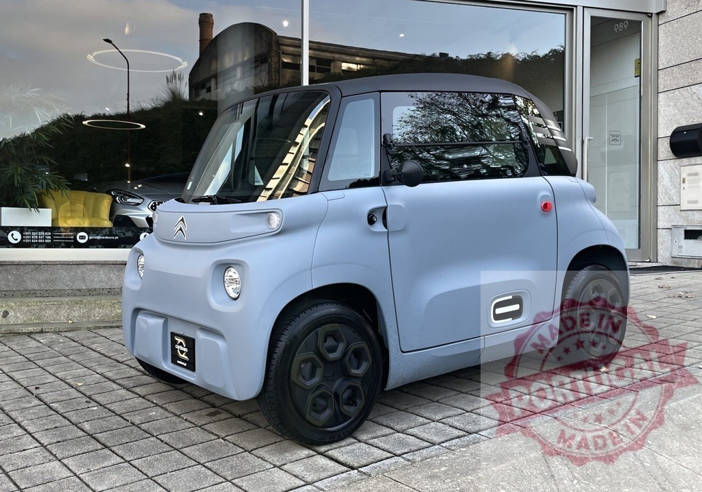 Citroen Ami electric microcar parked outdoors | Citroen Ami electric city car parked in front of a building, representing sustainable urban mobility - Realisiert mit Pictrs.com