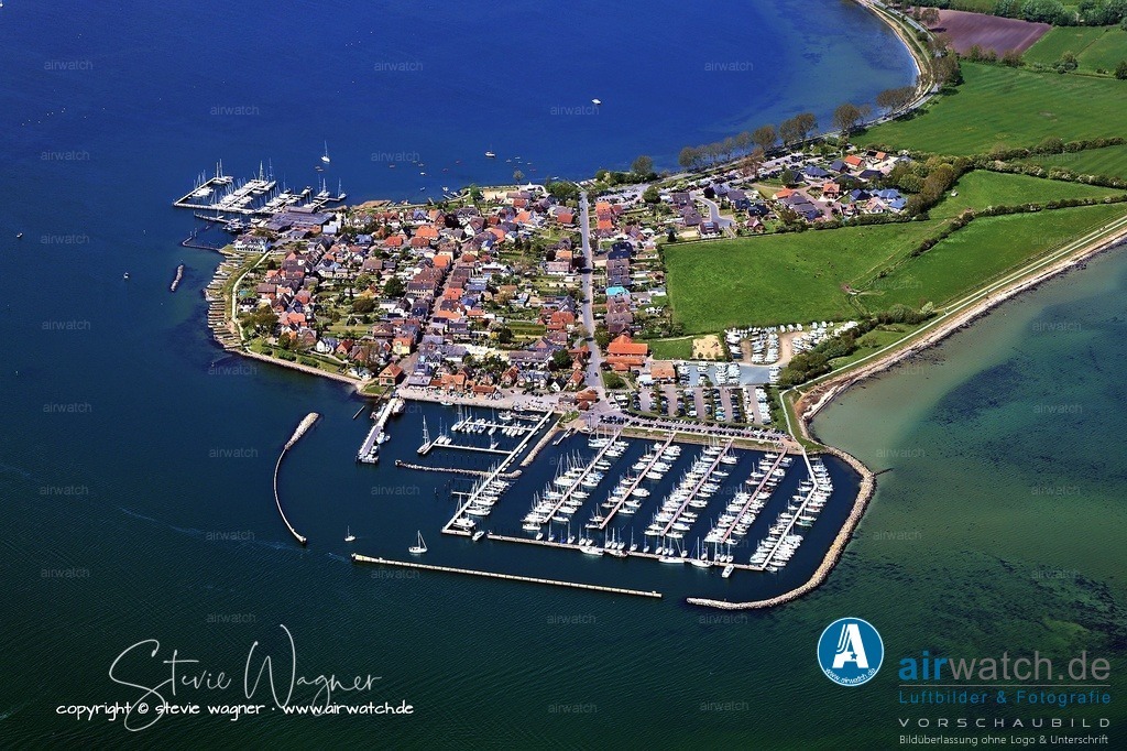Luftbilder Ostseefjord Schlei, Maasholm, Port Olpenitz, Schleimünde | Die Gemeinde Maasholm hat eine bedeutende Fischräucherei, die 1957 von Gerhard Petersen gegründet wurde, sowie eine Rettungsstation der Deutschen Gesellschaft zur Rettung Schiffbrüchiger (DGzRS), die seit 1918 in Maasholm präsent ist. Seit 2025 ist Maasholm wieder Doppelstation, da der Seenotkreuzer mit fest angestellter Besatzung von Olpenitz hierher verlegt wurde. Das Naturerlebniszentrum NEZ, das auf dem Gelände einer ehemaligen Bundeswehr-Raketenstellung errichtet wurde, beschäftigt sich mit der Geschichte der Fischerei, Meeresbiologie und Naturschutz.