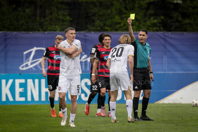 Viktoria Koeln vs. SV Wehen Wiesbaden, 11.04.2026 | KOELN, GERMANY - APRIL 11, 2026:  referee Cengiz Kabalakli (Gelsenkirchen) shows Ryan Johansson (SV Wehen Wiesbaden, 20) the yellow card during the 3rd division match between Viktoria Koeln vs. SV Wehen Wiesbaden at the Sportpark Hoehenberg on matchday 7 on April 11, 2026 in Koeln, Germany. DFL REGULATIONS PROHIBIT ANY USE OF PHOTOGRAPHS AS IMAGE SEQUENCES AND/OR QUASI-VIDEO.