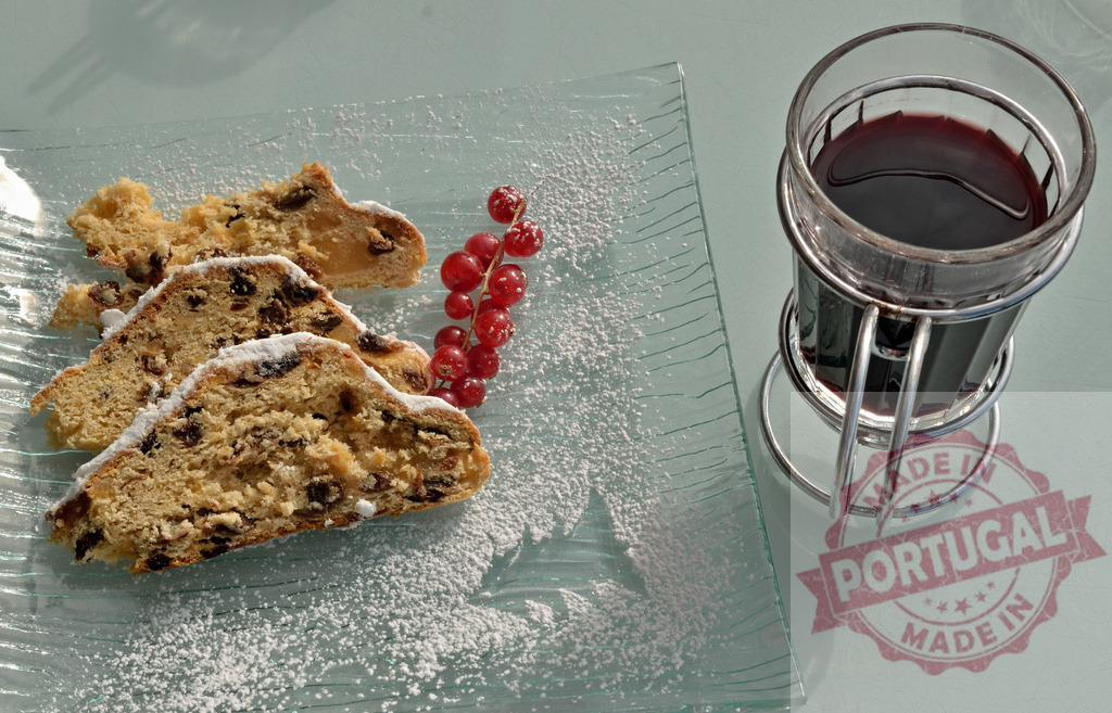Christstollen slices with powdered sugar and mulled wine | Christstollen slices, red currants, and mulled wine on a glass plate - Realisiert mit Pictrs.com