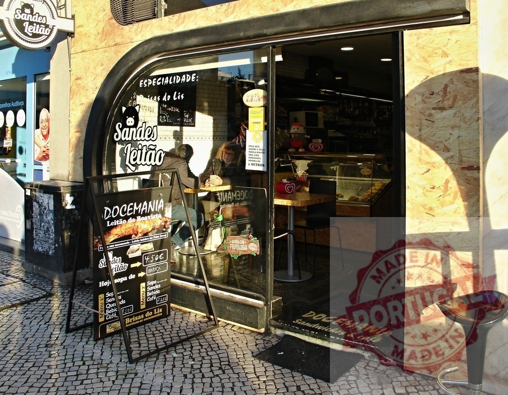 Portuguese Sandes Leitão shop showing an outdoor menu | Pedestrian street view of a small Lisbon takeaway cafe with people eating inside - Realized with Pictrs.com