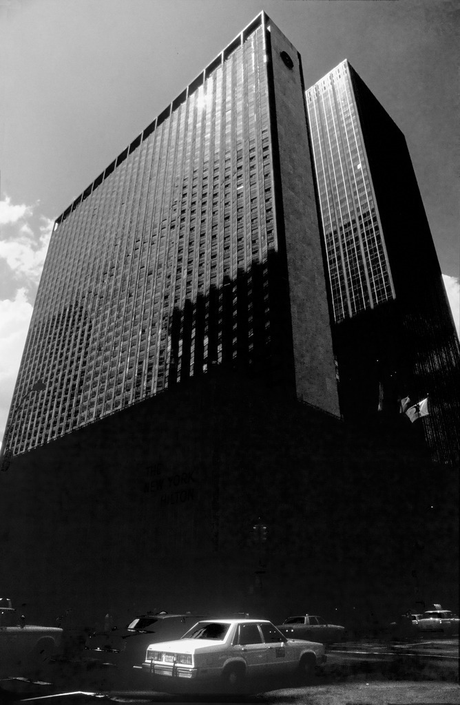 05USA_NYC_1983_5236_sw | NY Wolkenkratzer, schwarzes Gebäude. gelbes Taxi: sw-Foto