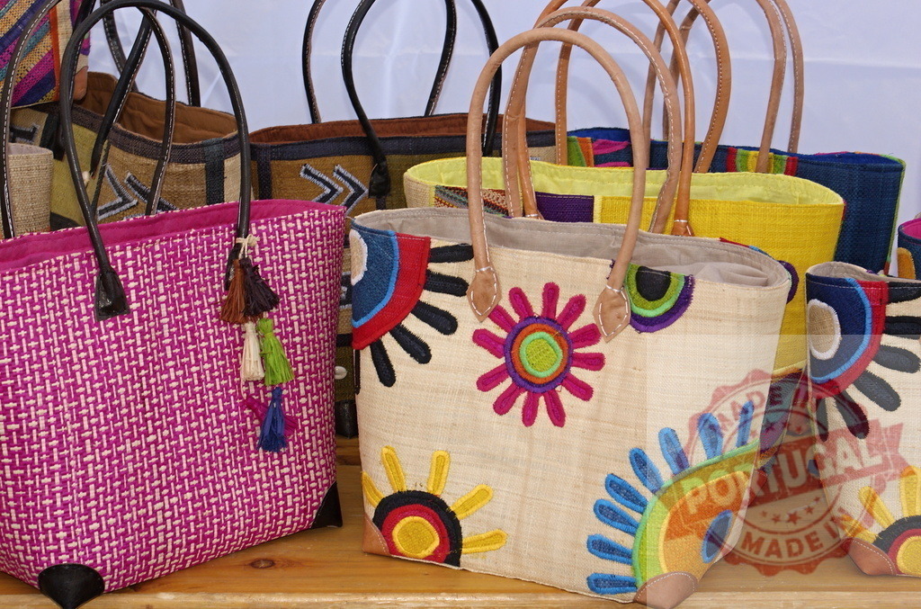 Colorful woven straw handbags with intricate embroidery design | Handcrafted woven straw handbags displaying colorful patterns and artisanal details on a shelf - Realized with Pictrs.com