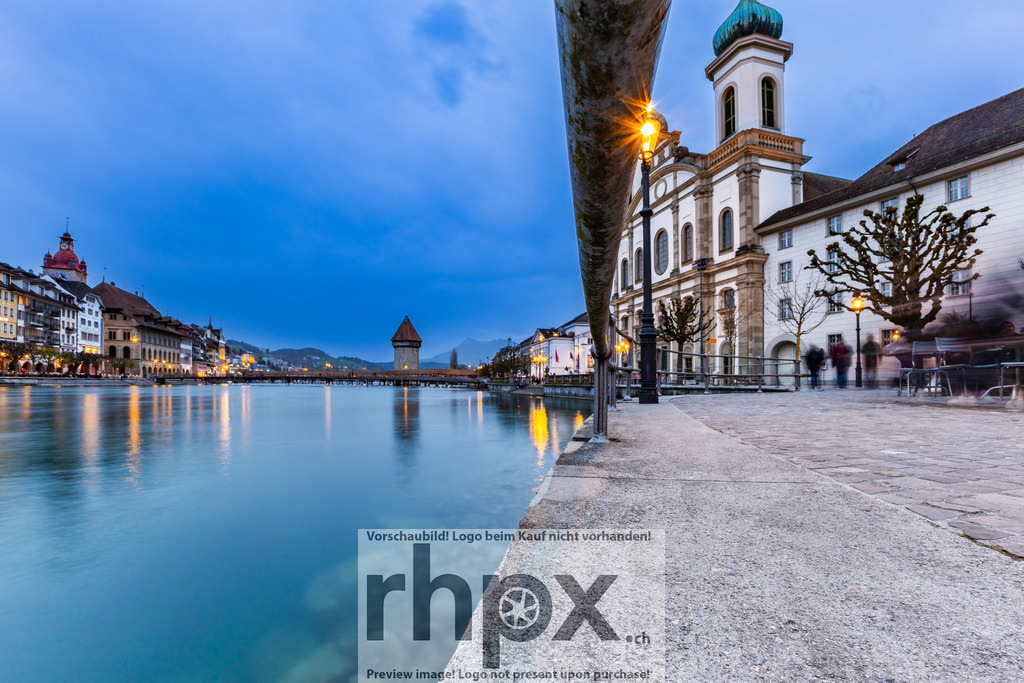 Jesuitenkirche Luzern am Reussufer / Jesuit Church Lucerne on the Reuss River | Aufnahme der Jesuitenkirche Luzern mit Blick entlang der Reuss. Das abendliche Licht sorgt für sanfte Farben und klare Spiegelungen auf dem Wasser. Im Hintergrund ist die Altstadt von Luzern zu erkennen. *************** Photograph of Lucerne’s Jesuit Church with a view along the Reuss River. The evening light creates soft tones and clear reflections on the water, while the old town of Lucerne appears in the background bathed in gentle color. - Realisiert mit Pictrs.com