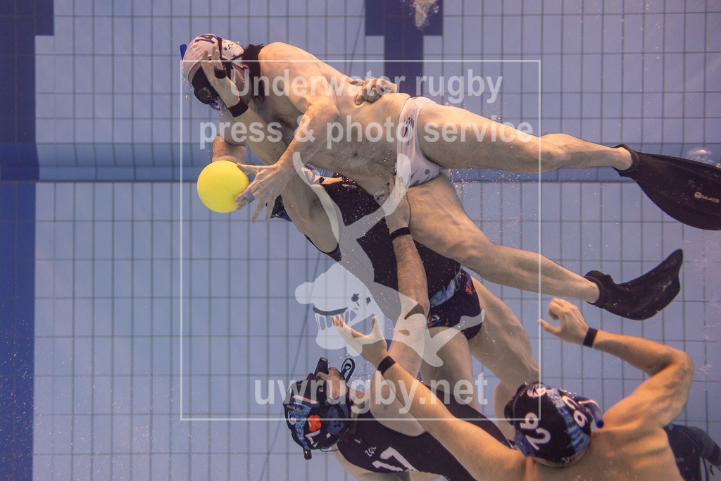 TC Stuttgart vs, TSV Malsch, Unterwasser-Rugby, 1. Bundesliga Süd, 5. Spieltag, 2024/2025, 23.03.2025 | TC Stuttgart (blau) vs, TSV Malsch (weiß). Mehrere Stuttgarter Spieler versuchen der ballführenden Malscher Spieler zu stoppen. - Realisiert mit Pictrs.com