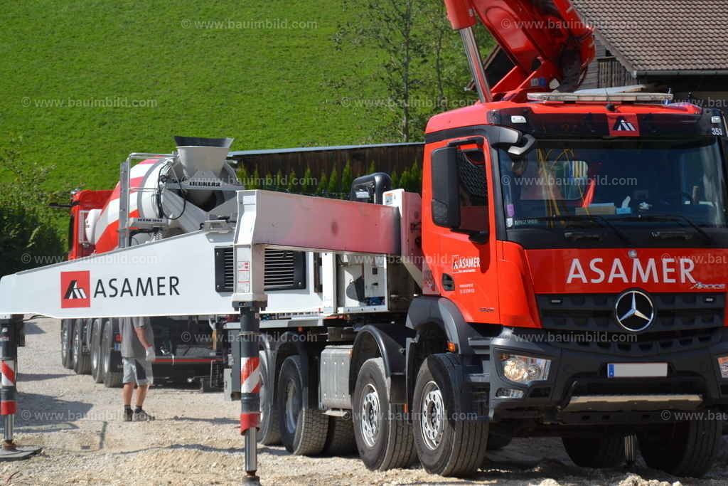 Betonpumpe und Fahrmischer | Roter LKW mit Auto-Betonpumpe, dahinter Fahrmischer mit Frischbeton