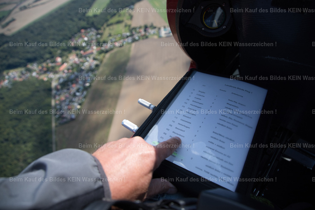 landkreis_börde_0569 | Im Cockpit muss jeder Handgriff sitzen.Während des Fluges arbeite ich gleichzeitig mit Kamera, Handy und Papierkarten. Auf dem Handy befinden sich die vorbereiteten Motive, auf der Karte sind Flugrouten und Himmelsrichtungen eingezeichnet. So finden wir auch kleine Orte  und verlieren nie die Orientierung. - Realisiert mit Pictrs.com