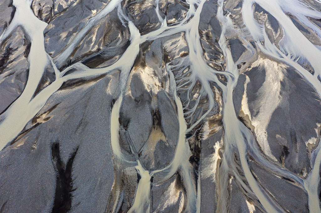 island-DJI_0290 | Der Fluss Markarfljót in Island entspringt im Gebirgsmassiv der Rauðufossafjöll, östlich des Vulkans Hekla. Er strömt durch enge Schluchten, bis er auf die weite Sandurebene des Südlandes in der Nähe der Þórsmörk hinaustritt. Hier entstand dieses Luftbild des Deltas. - Realisiert mit Pictrs.com