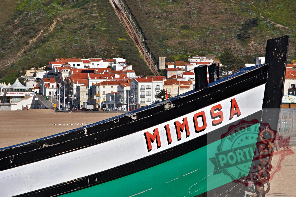 Mimosa fishing boat on Nazaré beach, Portugal | Traditional fishing boat Mimosa resting on the sand with Nazaré town in background - Realisiert mit Pictrs.com