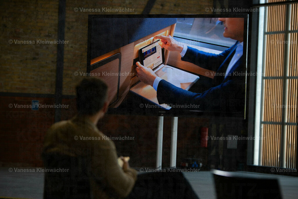 Deutsche Bahn stellt neues ICE-Design vor | Person vor einem großen Bildschirm, auf dem ein Blick ins Innere des ICE-Modells übertragen wird. Zu sehen ist, wie ein Tablet in die Halterung am Sitz befestigt wird.

Berlin, 18.05.2022: In der STATION stellt die Deutsche Bahn ihr neues ICE-Design mit einem begehbaren Modell vor. Neuerungen sind etwa das Material der Sitze und die Ergänzung einer Tablethalterung. Ende 2023 sollen die ersten ICEs mit dem neuen Design auf die Schiene kommen. - Realisiert mit Pictrs.com
