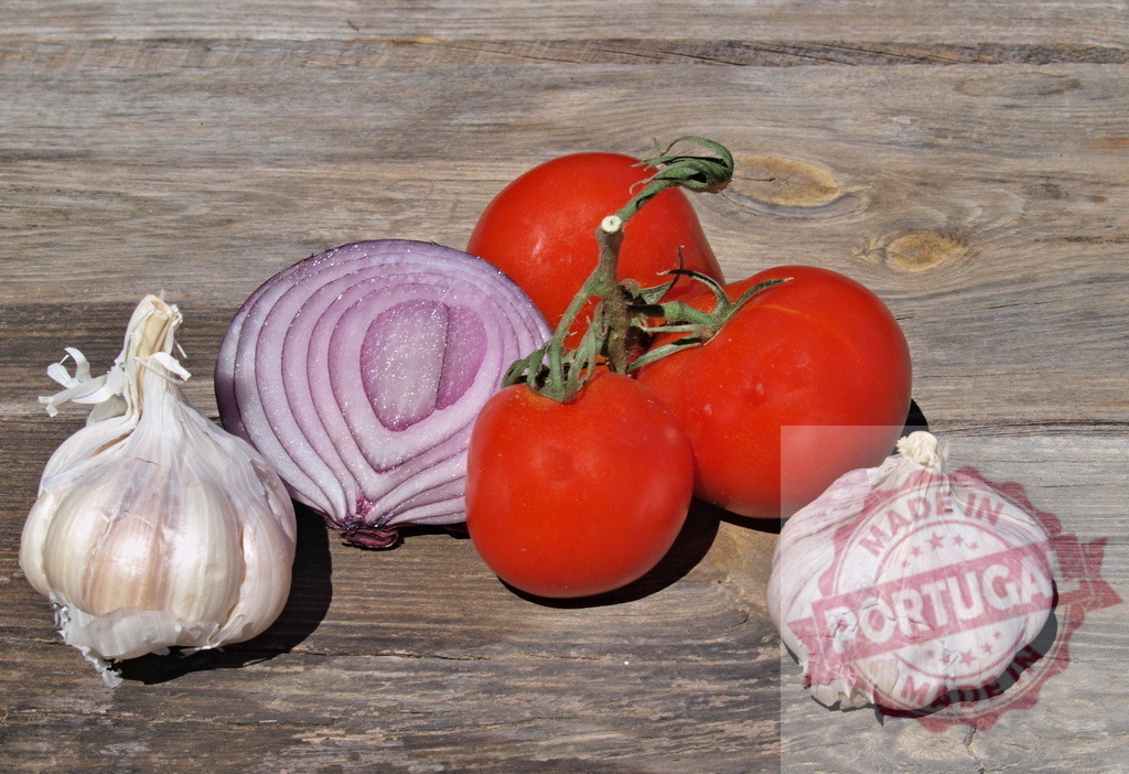 Fresh tomatoes red onion and garlic on rustic wood | Vegetables like fresh tomatoes, red onion, and garlic for cooking on a wooden surface - Realized with Pictrs.com