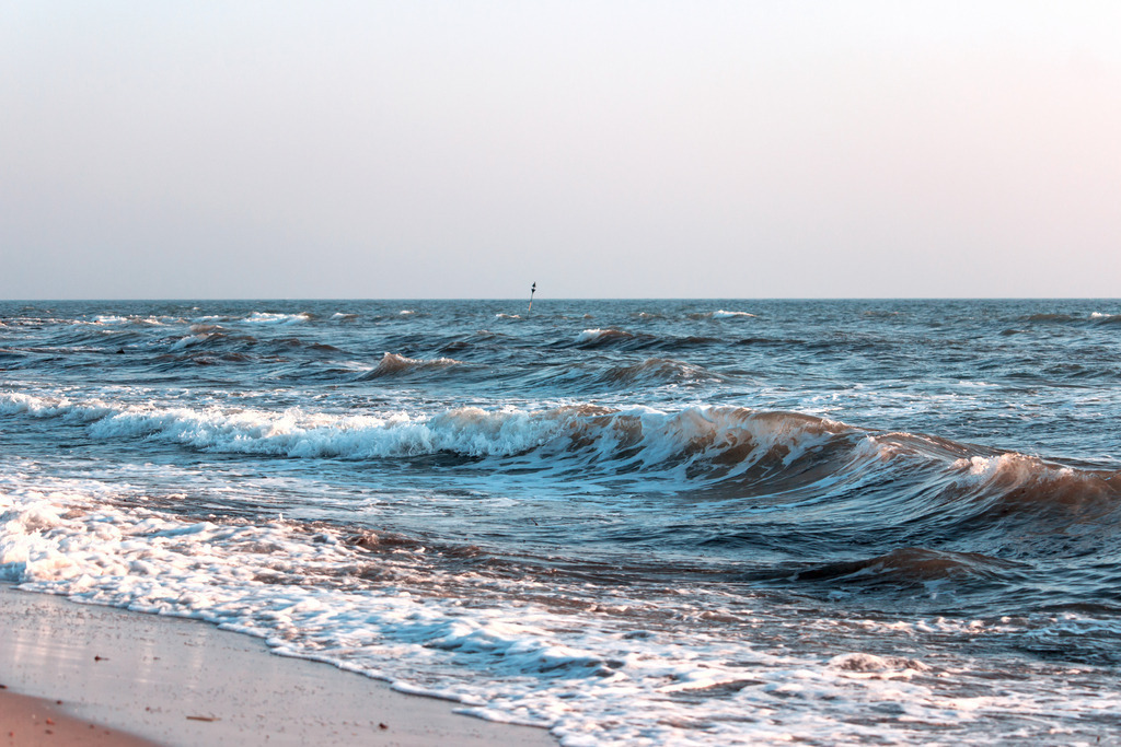Wandbild: Wellen im Morgenrot in dezenten Farben | Dieses Wandbild im Querformat zeigt das Meer am Morgen. Die Wellen sind grau und blau mit einer leicht rötlichen Note. Die auslaufende Welle spiegelt sich leicht auf dem nassen Strandsand. Holen Sie sich dieses traumhafte Strandmotiv in dezenten Farben auf Leinwand, auf Aluminium-Platte oder Acrylglas. Ideal fürs Wohnzimmer, Schlafzimmer, Küche, den Arbeitsplatz oder die Ferienwohnung. Die Wandbilder werden individuell für Sie in vielen Abmessungen produziert. Daher passen die Ostseekult Wandbilder immer perfekt an Ihre Wände.  - Realisiert mit Pictrs.com