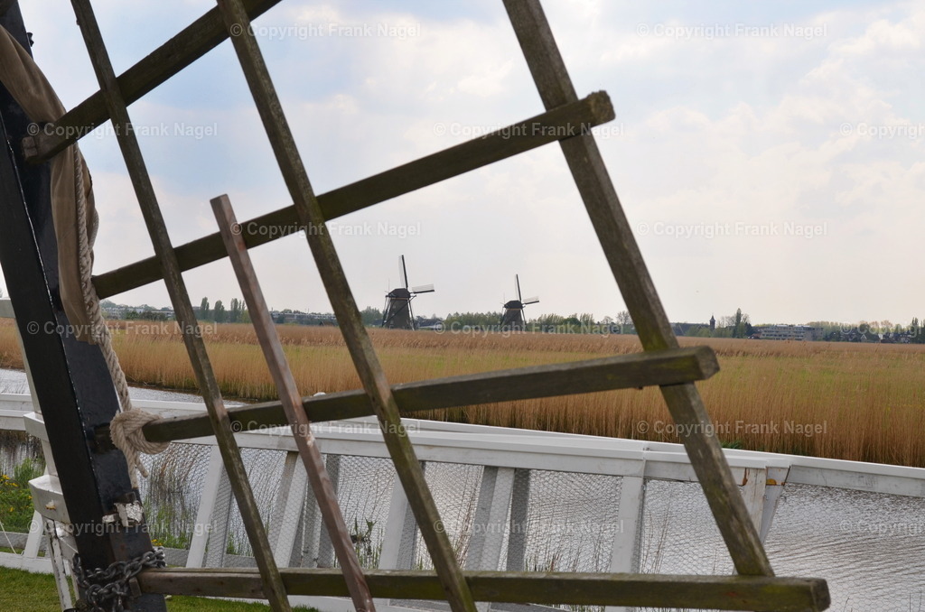 Windmühlen von Kinderdijk | Die 19 Windmühlen von Kinderdijk befinden sich 15 km von Rotterdam. Sie gehören zum UNESCO-Weltkulturerbe. Hier ein Blick durch ein Mühlen-Flügel-Gitter auf andere Mühlen. - Realisiert mit Pictrs.com