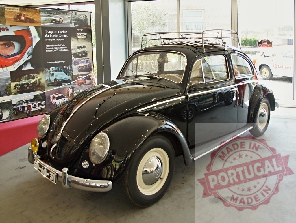 Classic Black Volkswagen Beetle Displayed in Showroom | Vintage Volkswagen Beetle showcased with historical racing memorabilia - Realized with Pictrs.com