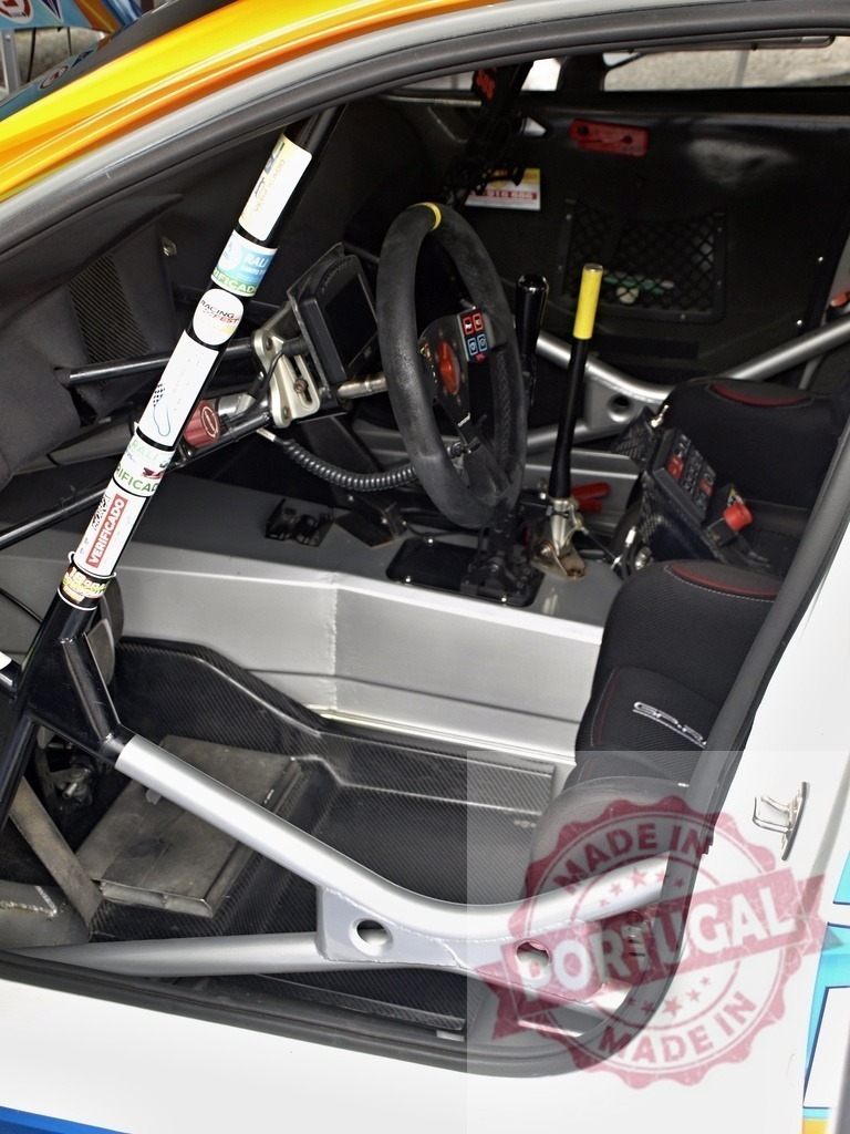 Rally car interior showing cockpit and safety equipment | Rally car cockpit featuring racing seat, steering wheel, and roll cage from the passenger side - Realisiert mit Pictrs.com
