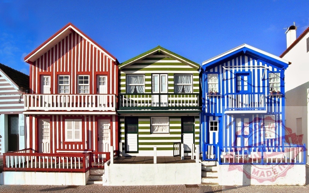 Costa Nova identifying with vibrant striped houses | Costa Nova houses feature iconic colorful stripes under a clear blue sky - Realized with Pictrs.com