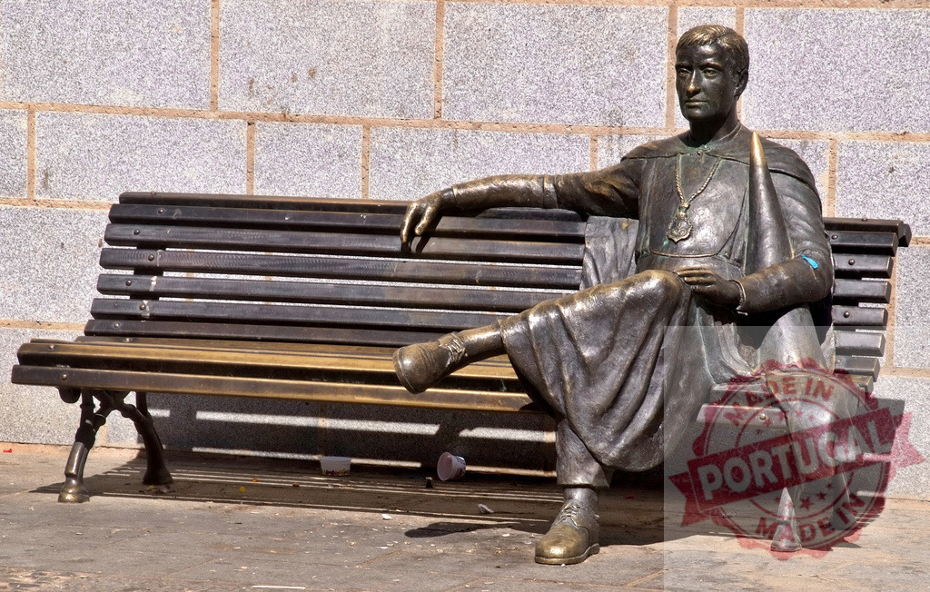 Bronze sculpture of figure sitting on park bench. Extremdura - Spain | Bronze statue of a seated figure wearing a robe, placed on a wooden bench - Realized with Pictrs.com