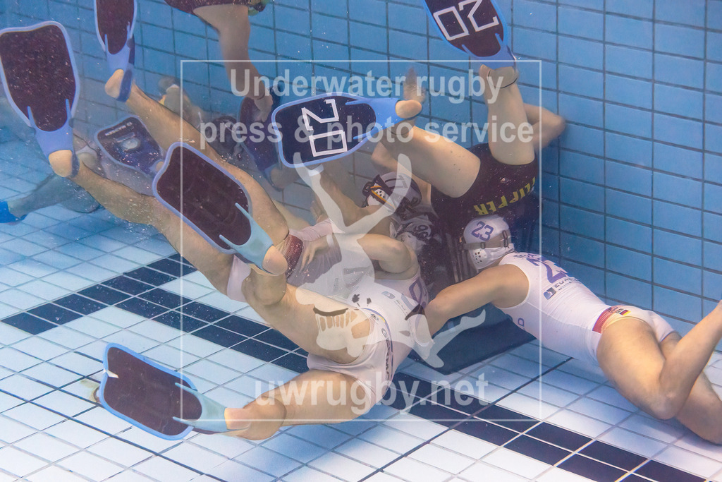 24. - 26.11.2023: Unterwasser-Rugby Champions Cup 2023  | Herren-Finale: Flippers (Dänemark) in blau gegen den DUC Krefeld (Deutschland) in weiß.  Drei Krefelder Spieler umzingeln das Tor des dänischen Meisters, aber der Ball ist noch in den Händen eines entfernten Mitspielers. - Realisiert mit Pictrs.com