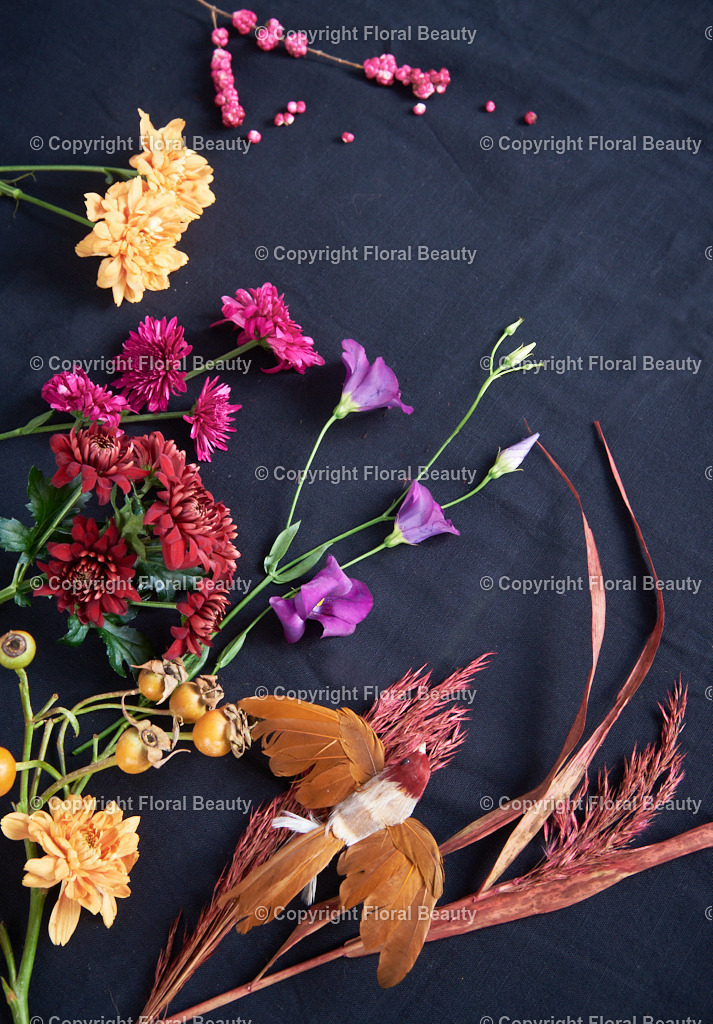 Bunte Blüten auf schwarzem Stoff gelegt | Chrysanthemen, Lisianthus und Pampasgras auf dunklem Stoff gelegt - Realisiert mit Pictrs.com