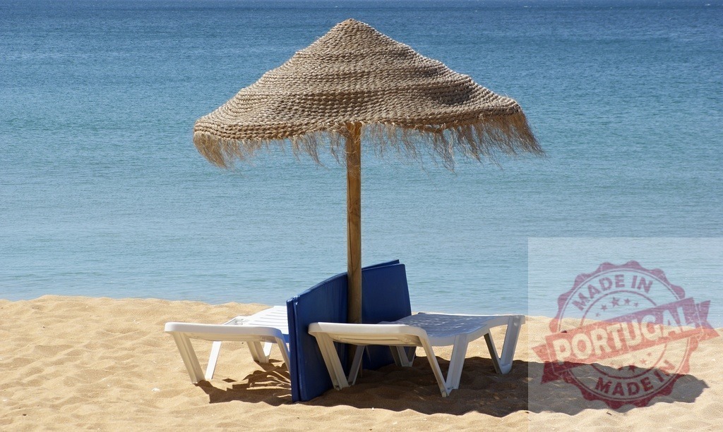 Thatched umbrella and beach loungers on sandy beach | Beach loungers and a thatched umbrella waiting on a sandy beach by the clear blue sea - Realisiert mit Pictrs.com