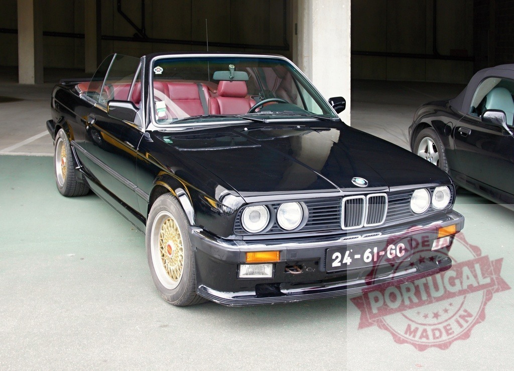Black BMW e30 convertible parked showing golden rims | Shiny black BMW e30 convertible with burgundy leather interior and golden rims parked in garage - Realisiert mit Pictrs.com