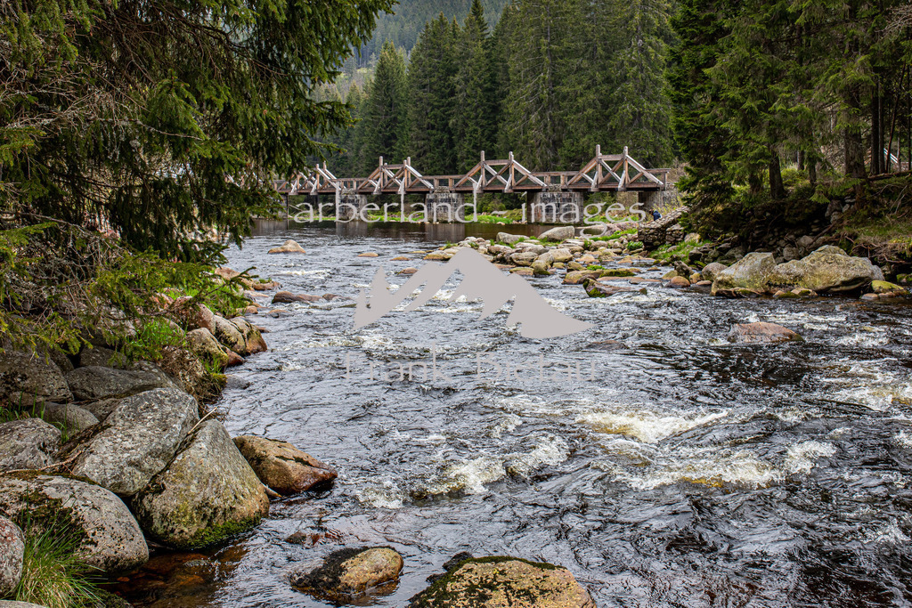 OE7A5452 | Die 72 m lange Brücke wurde zwischen 1799 und 1800 unter der Leitung des Fürstlich-Schwarzenbergischen Forstingenieurs Joseph Rosenauer als Eingangsbauwerk des Chinitz-Tettauer Schwemmkanals errichtet. Mittels von der Brücke in den Fluss hineingerammter Rundholzrechen wurde das vom Böhmerwaldkamm heruntergeflößte Stammholz abgefangen und aus der wegen der zahlreichen mächtigen Felsblöcke für die Flößerei untauglichen Vydra in den Schwemmkanal abgeleitet.