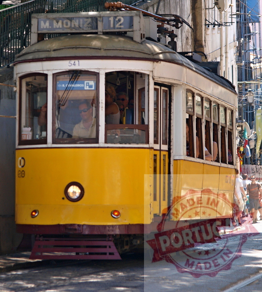 Yellow Lisbon Tram Number 12 Carrying Passengers in Alfama District | Passengers riding a vintage yellow tram number 12 in the historic Alfama district of Lisbon, Portugal - Realisiert mit Pictrs.com