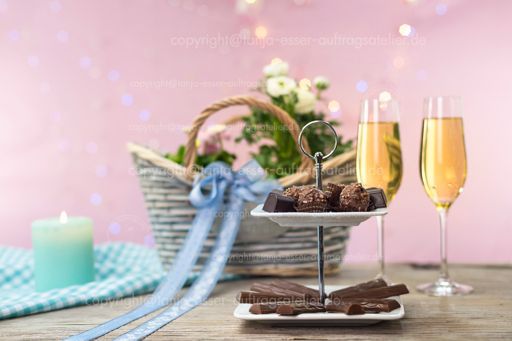 Holiday in the spring with little delights | Festtage im Frühling mit kleinen Köstlichkeiten
. Sekt und Schokoladen Pralinen vor Frühlingsblumen im Korb.