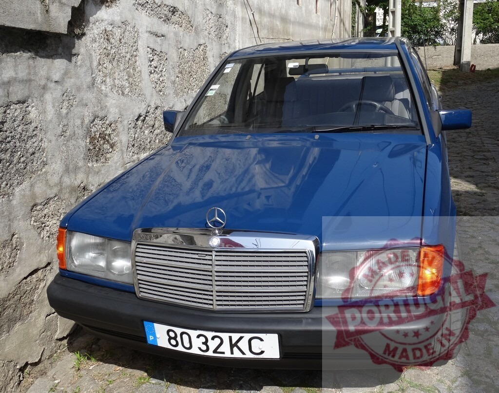 Blue Mercedes-Benz W201 190E parked on cobblestone street in Portugal | Mercedes-Benz W201 190E vintage car parked on a traditional cobblestone street - Realized with Pictrs.com