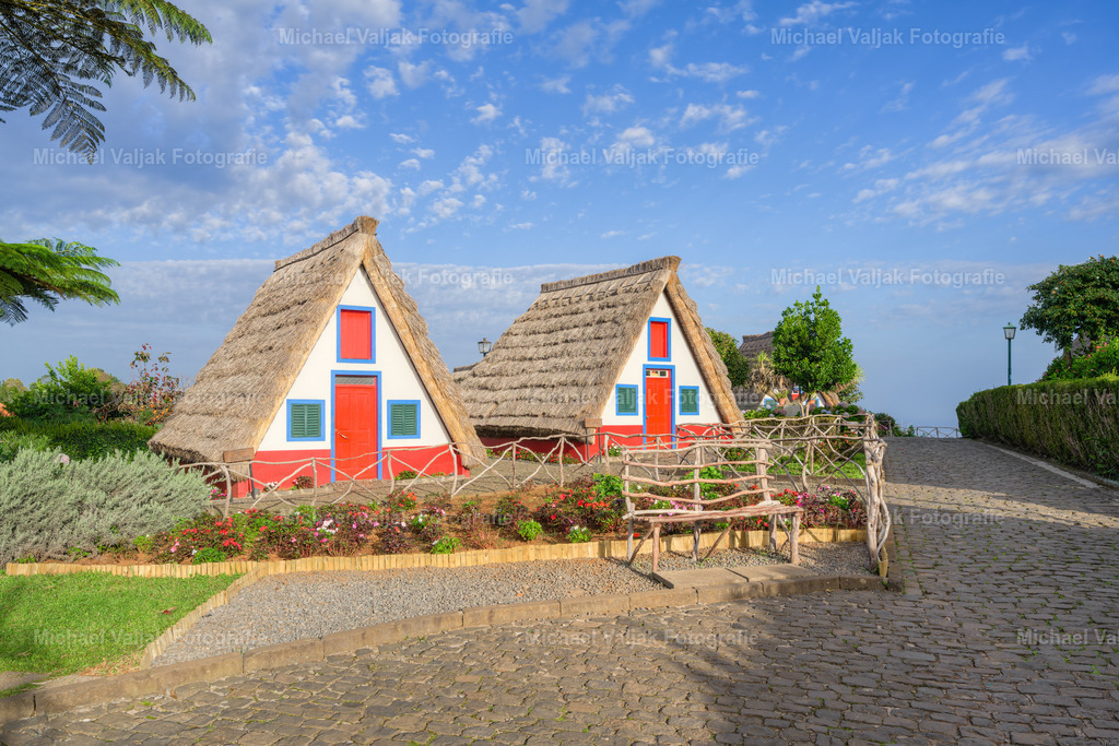 Traditionelle Häuser in Santana auf Madeira | Die traditionellen Häuser in Santana auf Madeira sind ein faszinierendes Beispiel für die lokale Architektur und Kultur. Diese charmanten, dreieckigen Häuser, bekannt als "Casas de Colmo", sind mit Strohdächern gedeckt und haben bunte Fassaden, die oft in Weiß, Blau und Rot gestrichen sind. Ursprünglich wurden sie von den Bauern der Region als Wohnhäuser genutzt und bieten einen Einblick in das ländliche Leben auf Madeira.Die Häuser sind aus Naturmaterialien wie Holz und Stroh gebaut, was sie gut an das Klima der Insel anpasst. Das Strohdach, das bis zum Boden reicht, schützt vor Regen und Sonne und sorgt für eine angenehme Temperatur im Inneren. Viele dieser Häuser sind heute restauriert und dienen als Touristenattraktionen, die das kulturelle Erbe Madeiras bewahren.Ein Besuch in Santana bietet die Möglichkeit, diese einzigartigen Gebäude zu besichtigen und mehr über die Geschichte und Traditionen der Insel zu erfahren. Die traditionellen Häuser sind ein Symbol für die handwerkliche Geschicklichkeit und den Einfallsreichtum der Madeirenser und ein wichtiger Teil des kulturellen Erbes der Insel. - Realisiert mit Pictrs.com