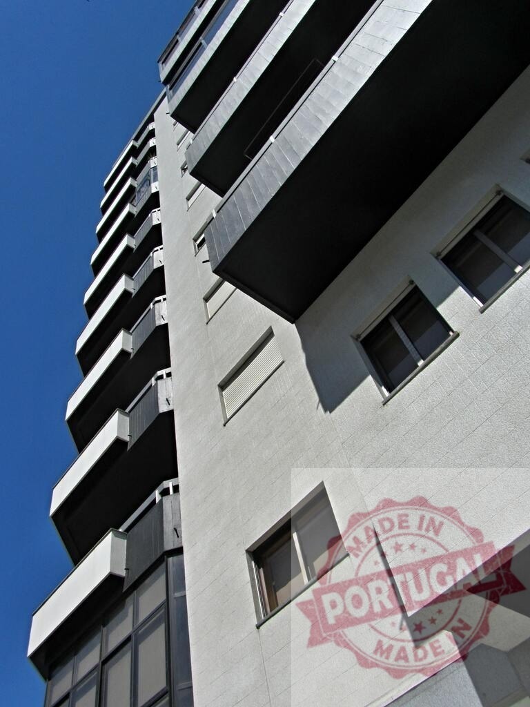 Modern building architecture reaching into clear blue sky. Norte - Portugal | Modern apartment building with balconies and geometric facade against a clear sky - Realized with Pictrs.com