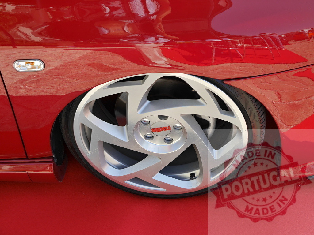 Red street car displaying custom silver rim and tire | Red car showing custom low profile wheel and tire, highlighting automotive tuning concept - Realized with Pictrs.com