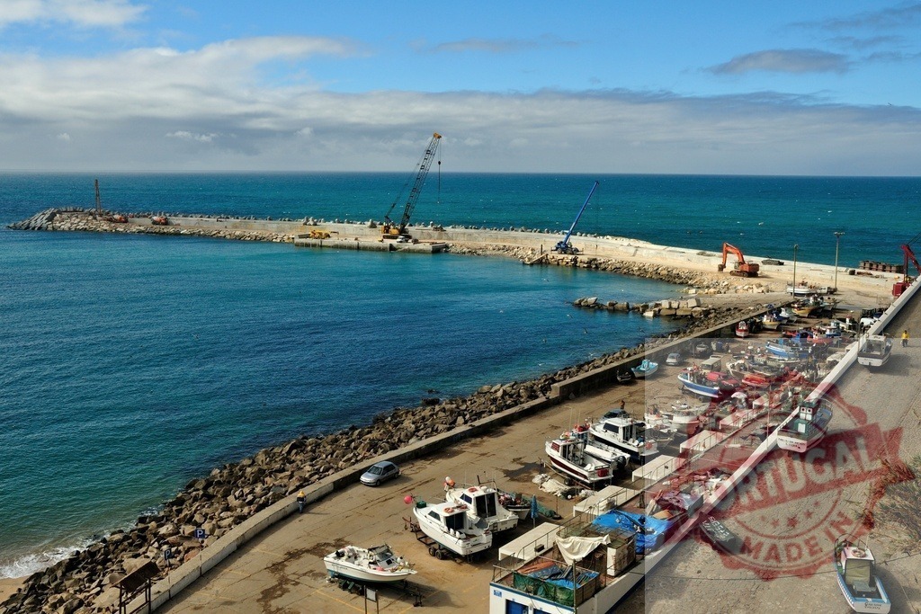 Port construction and fishing boats along the coast | Harbor expansion works with cranes and many small boats on dry dock along the coastline - Realisiert mit Pictrs.com