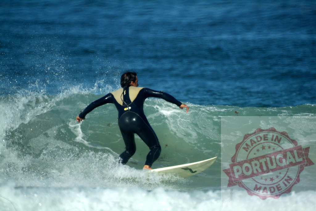 Surfer riding a wave in the ocean wearing a wetsuit | Surfer riding a wave in the ocean wearing a wetsuit - Realisiert mit Pictrs.com