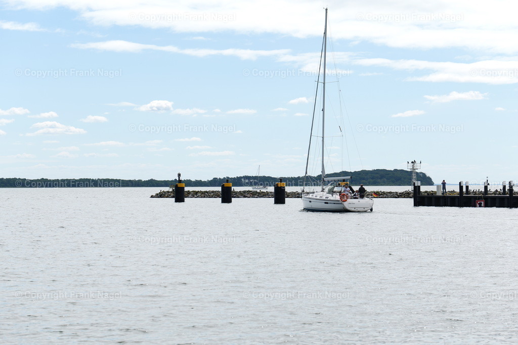 Hafenausfahrt Lauterbach mit Segelboot | Ein Segelboot verlässt die Hafenausfahrt - Realisiert mit Pictrs.com