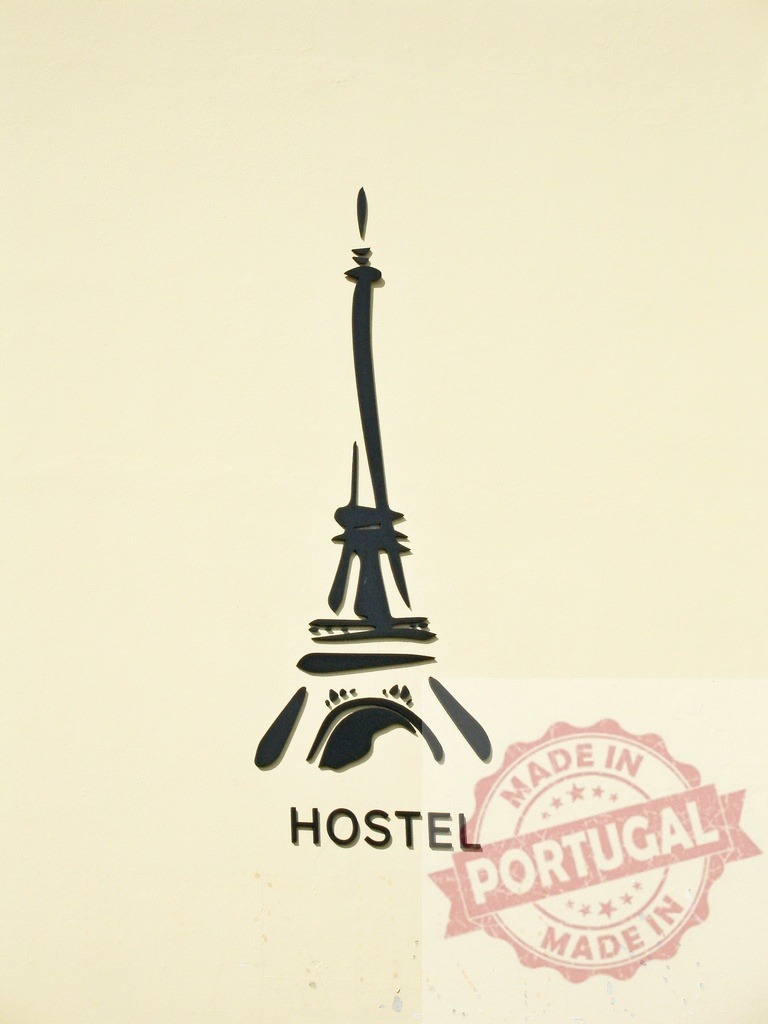 Eiffel Tower hostel logo sign on wall | Minimalist Eiffel Tower and hostel word sign, representing travel to Paris - Realisiert mit Pictrs.com