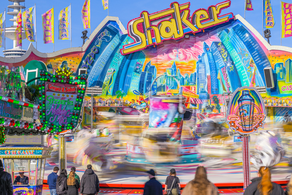 Shaker – Hamburger Dom | Shaker ist ein Fahrgeschäft, in dem die Fahrgäste in Gondeln sitzen, während sie in nahezu alle Richtungen gedreht und geschüttelt werden. Die Fotografie des Shakers entstand auf dem Hamburger Dom, die Gondeln verwischen für Betrachter bei ihren dynamischen Bewegungen. — Auflösung des Originals: 8256 x 5504 px. - Realisiert mit Pictrs.com