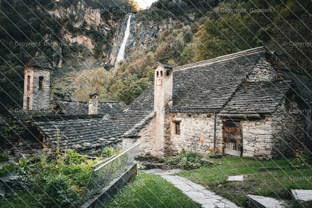 Foroglio Waserfall mit Kirche | Foroglio ist ein malerisches Bergdorf im Bavonatal im Tessin, Schweiz. Es ist bekannt für seinen beeindruckenden Wasserfall, der rund 80 Meter tief in das Tal stürzt, sowie für seine traditionellen Steinhäuser, engen Gassen und unberührte alpine Landschaft. Das Dorf wirkt wie aus einer anderen Zeit und zieht Natur- und Fotoliebhaber gleichermaßen an.