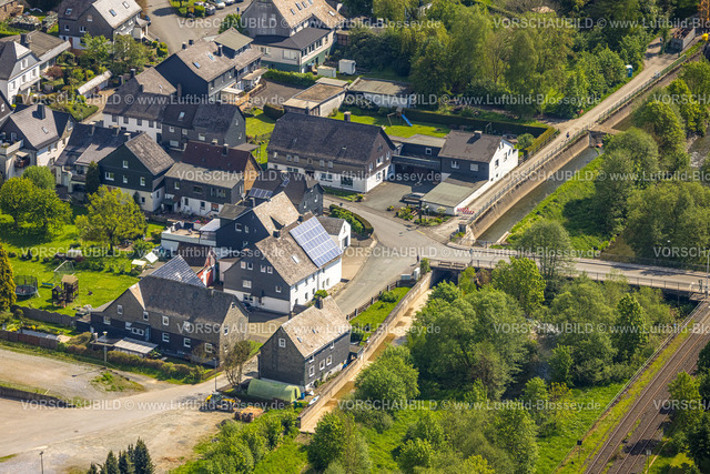 Bestwig240502872 | Luftbild, Wohngebiet Mühlenstraße Ecke Kanalstraße, Bahnlinie Bahnübergang und Ruhrbrücke Kanalstraße, begrünter Fluss Ruhr, hinten das Stauwehr Velmede, Velmede, Bestwig, Sauerland, Nordrhein-Westfalen, Deutschland